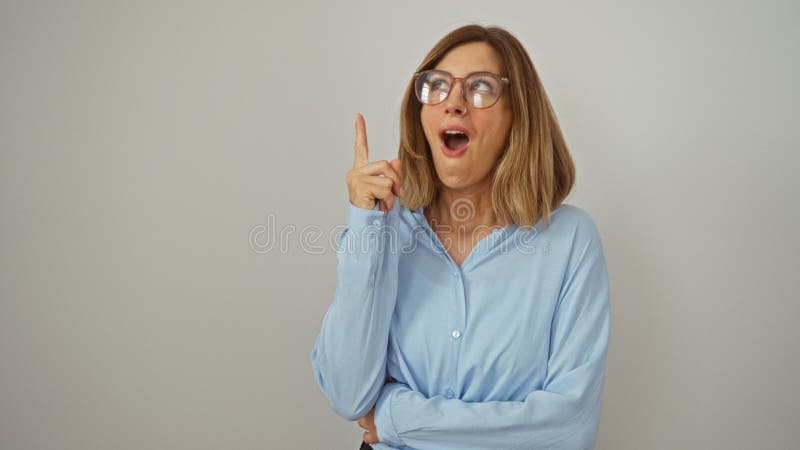 Joven rubia con gafas de pie con el dedo apuntando en idea y gesto de éxito feliz y emocionado por el aislamiento almacen de metraje de vídeo