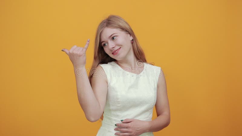 Joven rubia encantadora haciendo gesto rocoso, luciendo feliz metrajes