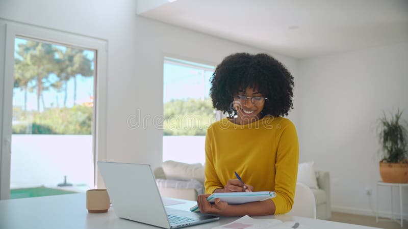 Joven sonriente estudiante afroamericana usando elearning portátil en casa. almacen de video