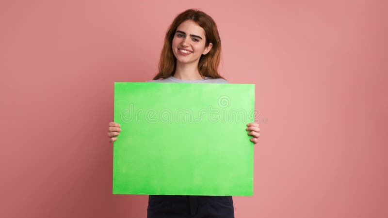 Joven sonriente sosteniendo una tabla verde almacen de metraje de vídeo