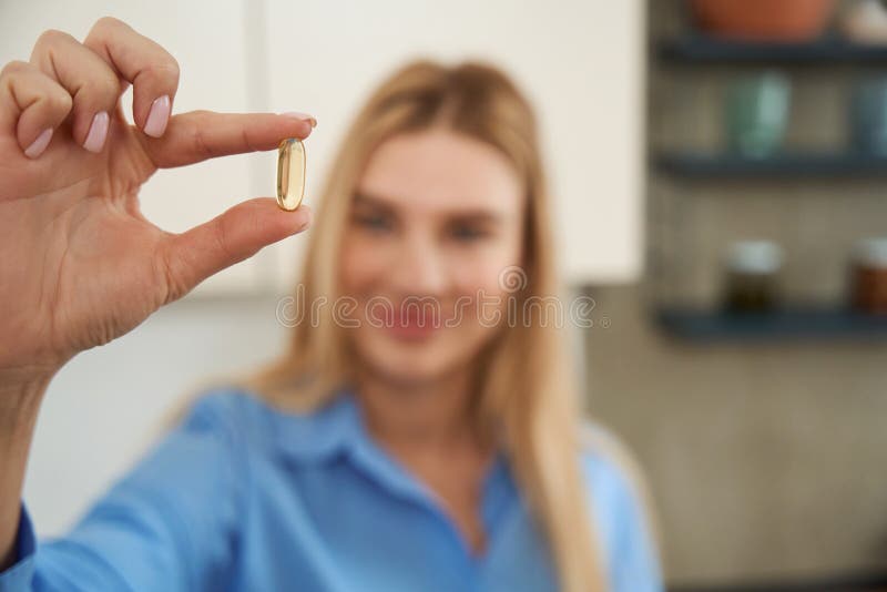 Joven sonriente sostiene cápsula de medicina transparente foto de archivo libre de regalías