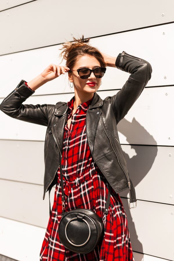 Joven Urbana Con Ropa Juvenil De Moda Con Bolso Negro Enderezo Gafas Sol Y Cabello Elegantes Cerca De La Moderna Pared Sobre S Foto de archivo - de inconformista: