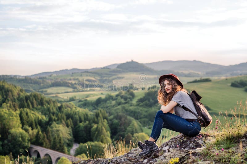 Joven viajera con mochila sentada en la naturaleza fotos de archivo Joven viajera con mochila sentada en la naturaleza fotos de archivo