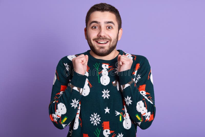 Joven y alegre hombre atractivo celebrando su éxito, joven barbudo gritando de victoria y levantando puños, hombre guapo imagen de archivo libre de regalías Joven y alegre hombre atractivo celebrando su éxito, joven barbudo gritando de victoria y levantando puños, hombre guapo imagen de archivo libre de regalías