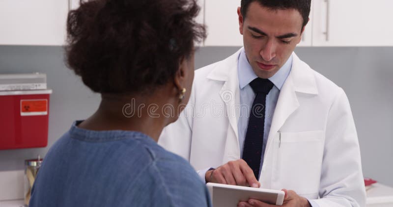 Joven y atractiva doctora hablando con la anciana africana sobre temas de salud almacen de metraje de vídeo