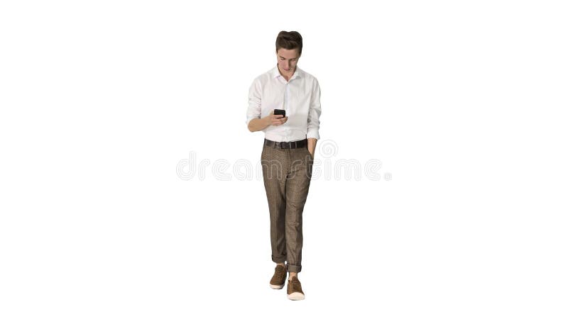 Joven y atractivo freelancer caminando y usando su teléfono sobre fondo blanco. metrajes
