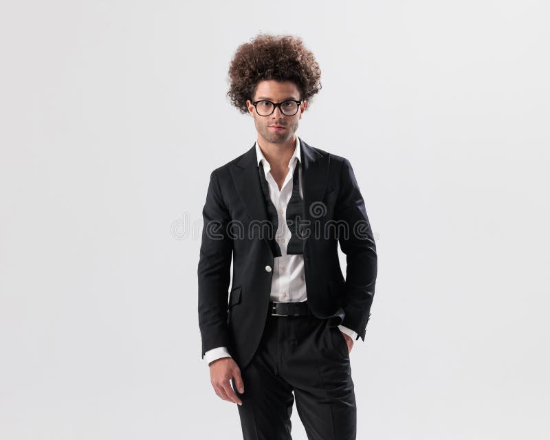 Joven y feliz empresario con gafas sosteniendo los bolsillos foto de archivo