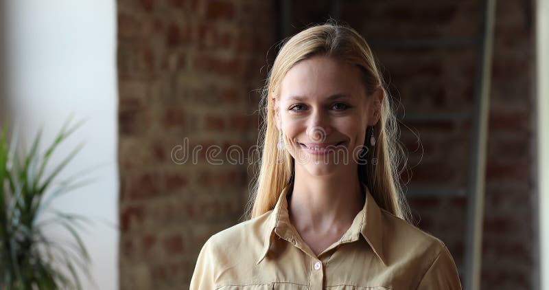 Joven y hermosa mujer rubia posando para un retrato de imagen en el taller almacen de metraje de vídeo
