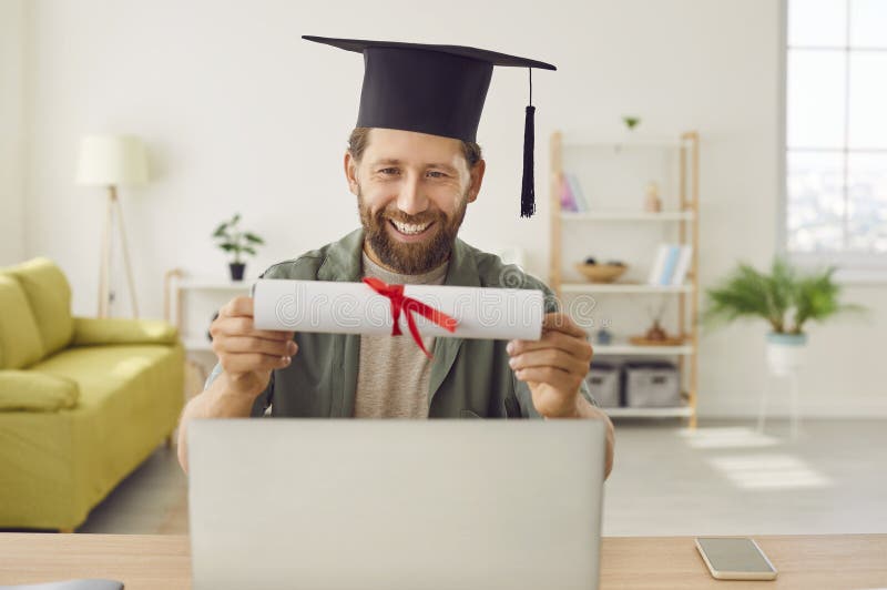 Joven y sonriente graduado con videollamadas en mano. imágenes de archivo libres de regalías