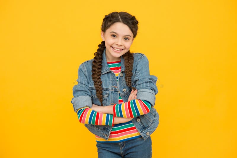 Jovencita alegre con trenzas ropa de denim concepto adolescente elegante fotos de archivo libres de regalías
