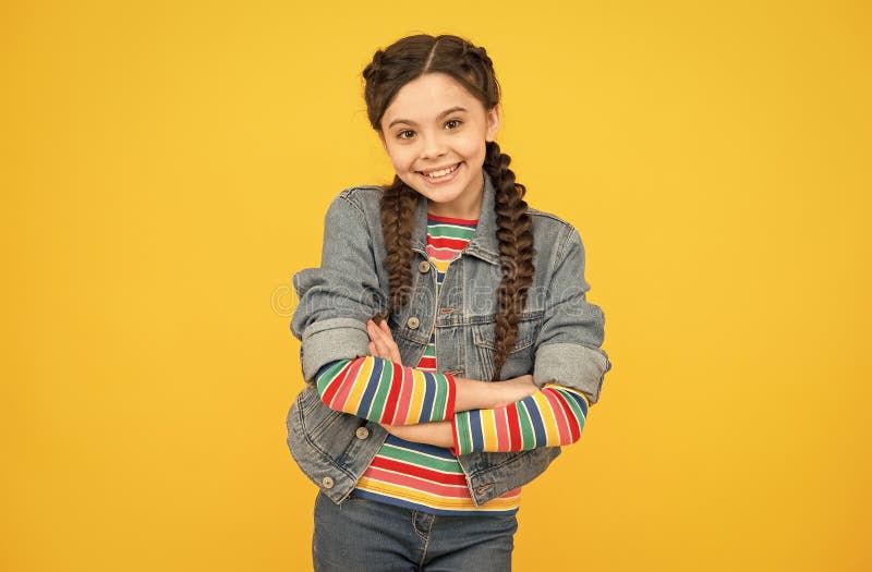 Jovencita alegre con trenzas ropa de denim concepto adolescente elegante imagenes de archivo