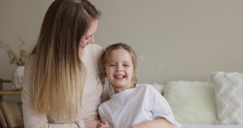 Jovencita alegre mamá haciendo cosquillas risas hija pequeña