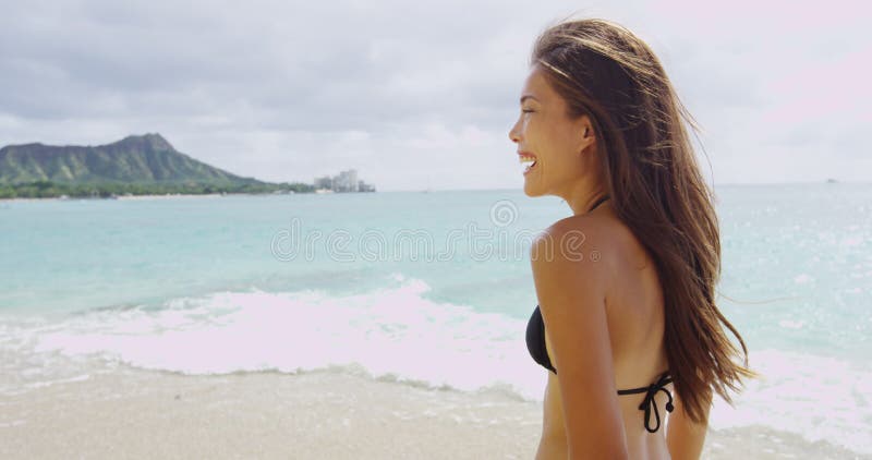 Jovencita alegre que disfruta de vacaciones en la playa de waikiki durante el verano