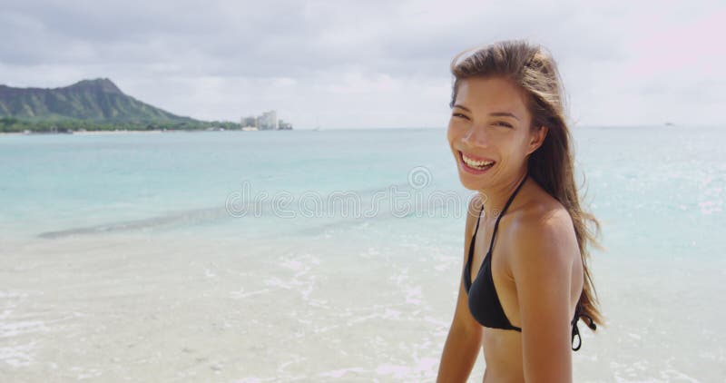 Jovencita alegre que disfruta de vacaciones de verano en la playa de waikiki