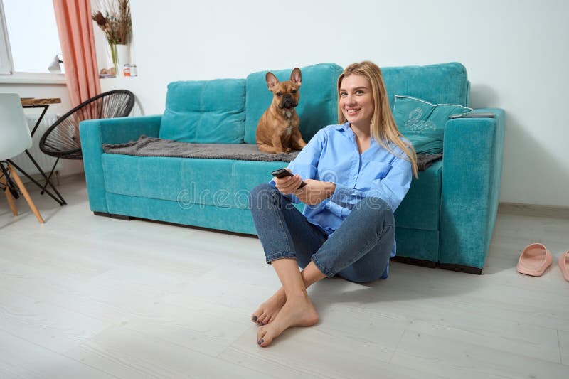 Jovencita alegre y perro viendo televisión imágenes de archivo libres de regalías