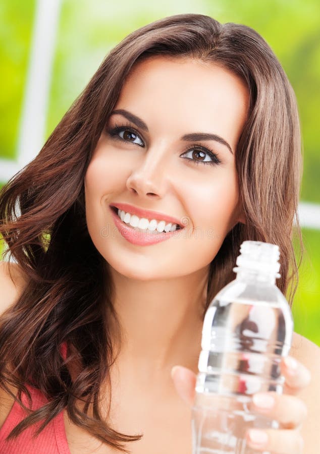 Jovencita feliz de pelo oscuro con botella de agua fotografía de archivo libre de regalías