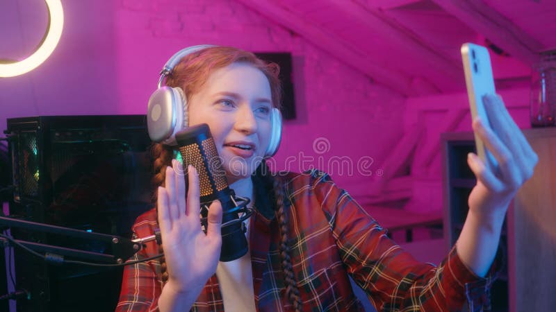 Jovencita mujer feliz juego hembra blogger influenciador vlogger ciberdeporte audífonos de jugador de radio récord de presentador fotos de archivo libres de regalías