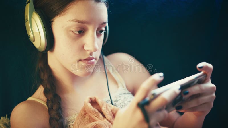 Jovencita relajada disfrutando del tiempo de la pantalla en un ambiente acogedor almacen de video