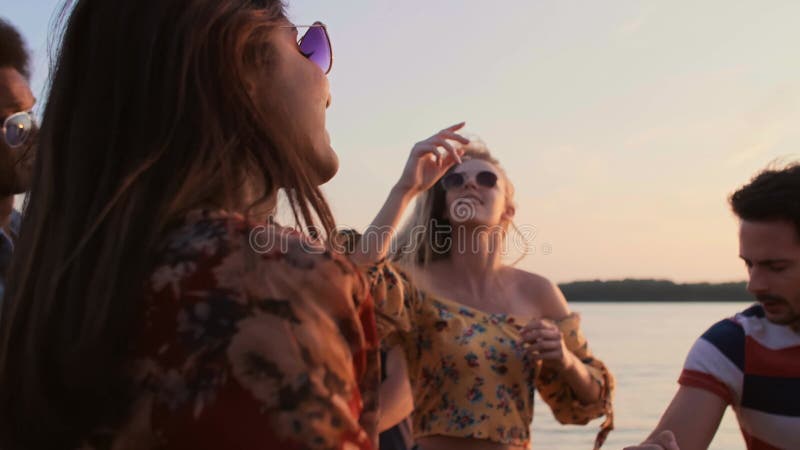 Jovens dançando juntos durante o belo pôr do sol