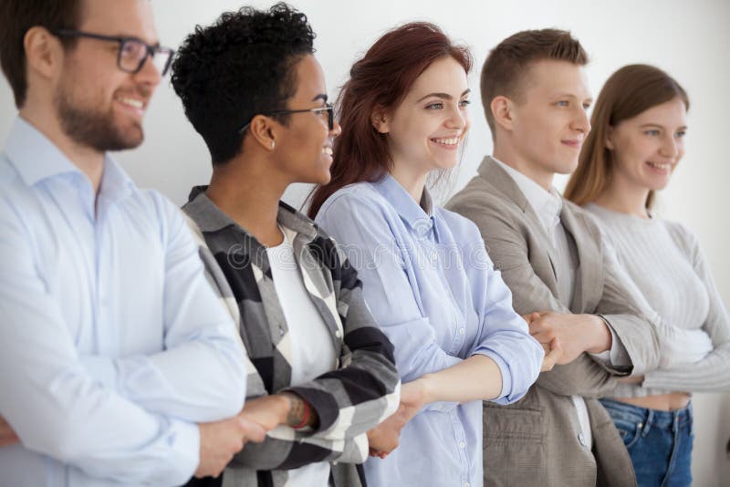 Jovens diversos que guardam as mãos que mostram a unidade e os trabalhos de equipe imagem de stock royalty free Jovens diversos que guardam as mãos que mostram a unidade e os trabalhos de equipe imagem de stock royalty free