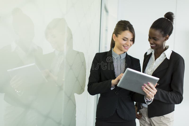 Jovens mulheres no escritório fotos de stock royalty free Jovens mulheres no escritório fotos de stock royalty free