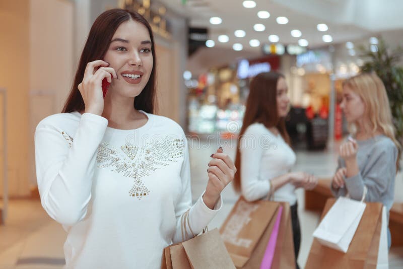 Jovens mulheres que apreciam a compra junto na alameda foto de stock Jovens mulheres que apreciam a compra junto na alameda foto de stock