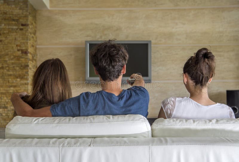 Jovens que olham a tevê foto de stock Jovens que olham a tevê foto de stock