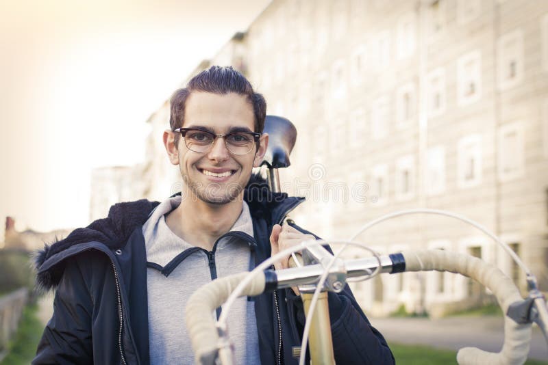 Jovem e na moda a transportar a bicicleta fotografia de stock royalty free