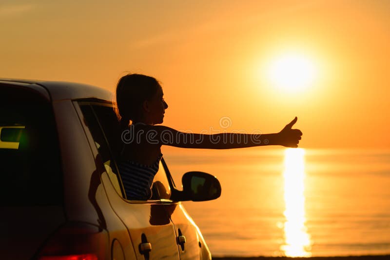 The joy of a girl from a trip to the sea by car