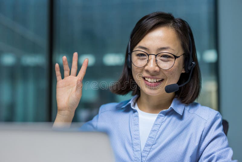 Joyeuse femme avec casque gros plan agitant main saluant client en ligne à distance. Support technique pour les travailleurs utili images libres de droits