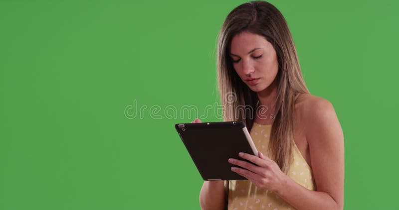 Joyeuse femme blanche millénaire utilisant ordinateur tablette sur écran vert