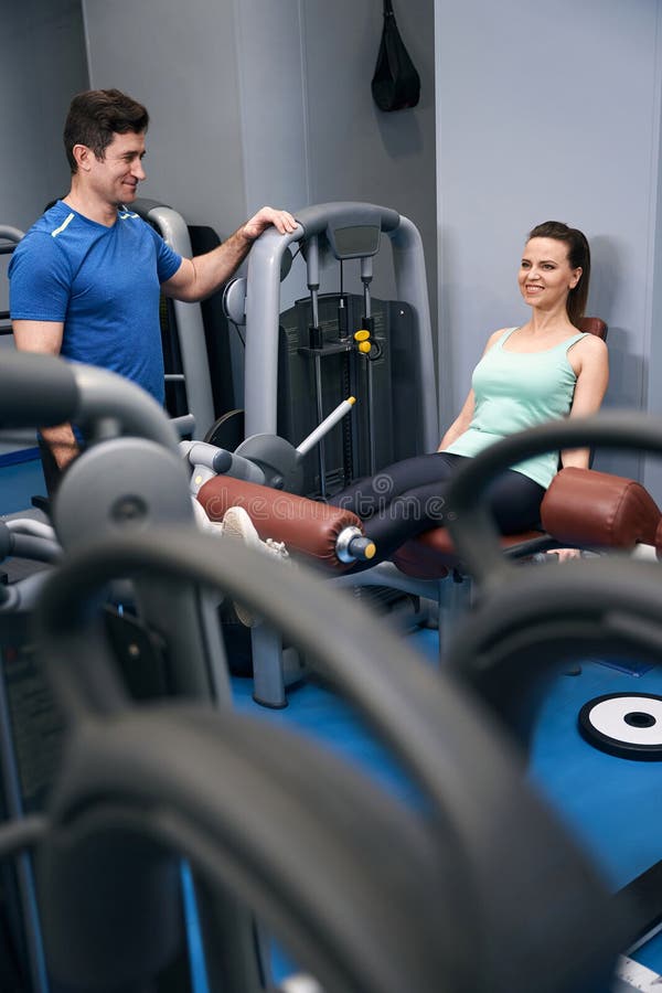 Joyeuse femme faisant de l'entraînement en bas corps sous la direction d'un instructeur de gym images libres de droits