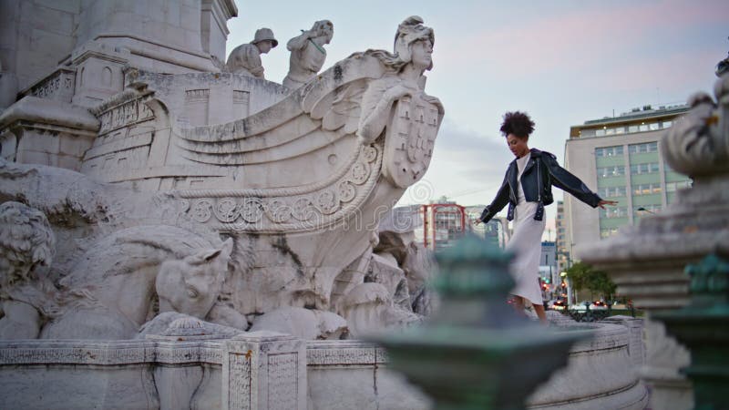 Joyeuse femme marchant monument dans la ville du soir. femme américaine africaine touristique clips vidéos