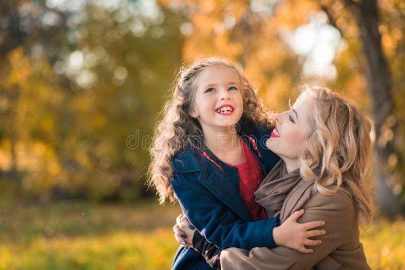 Joyeuse femme joyeuse s'amusant avec sa fille en couleur d'automne images libres de droits