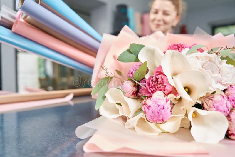 Joyeuse fleuriste femelle tient du papier et beau bouquet de fleurs photo stock