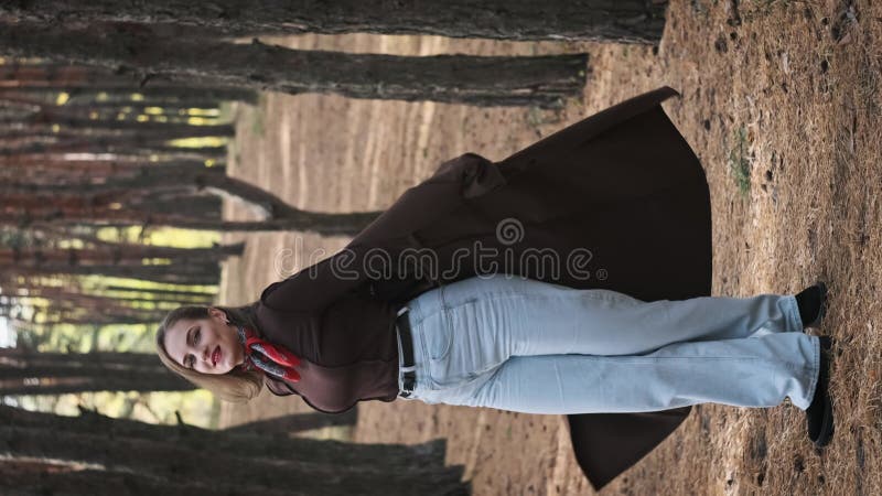Joyeuse Jeune Femme Spins et Posing parmi la forêt de pins en mouvement lent banque de vidéos