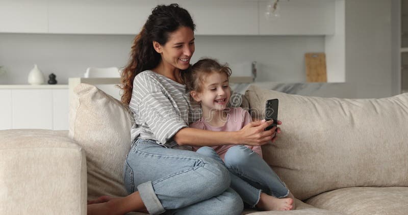 Joyeuse jeune mère et petit enfant préadolescent utilisant un téléphone cellulaire. banque de vidéos