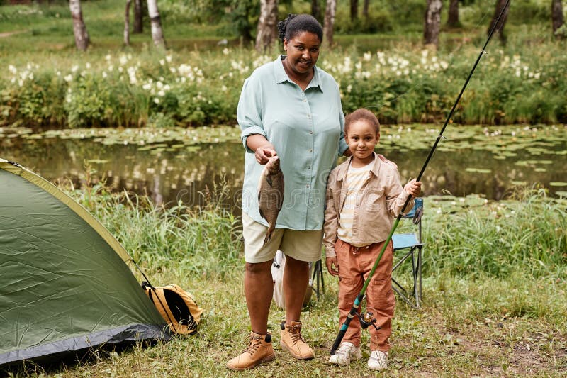 Joyeuse mère et fille pêchant ensemble en regardant la caméra photo stock