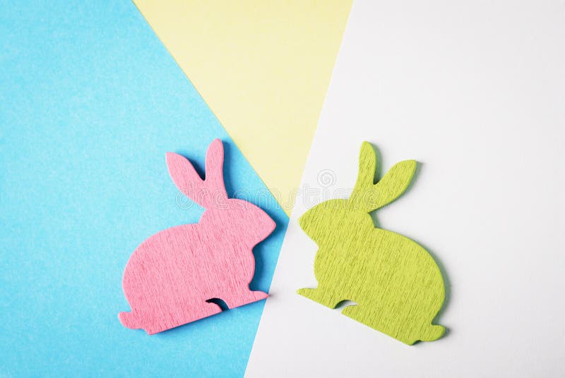 Joyeuses Pâques Rose et lapin de Pâques en bois vert sur un fond bleu et blanc et jaune Photo créative à la mode image stock Joyeuses Pâques Rose et lapin de Pâques en bois vert sur un fond bleu et blanc et jaune Photo créative à la mode image stock