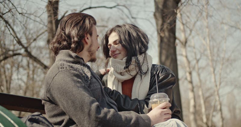 Joyeux couple amoureux Partager un verre et un baiser lors d'une journée ensoleillée d'hiver dans le parc banque de vidéos