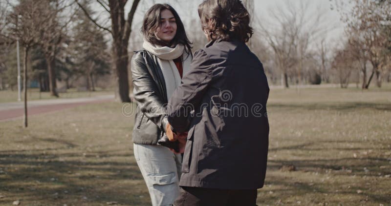 Joyeux couple amoureux Profitez d'une journée ensoleillée d'hiver dans le parc Tenir les mains et tourner autour clips vidéos