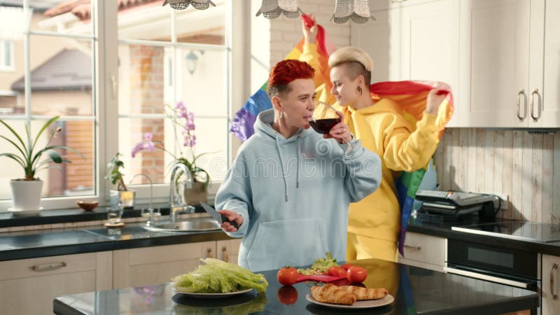 Joyeux couple lgbtq préparer le repas ensemble dans une cuisine moderne clips vidéos