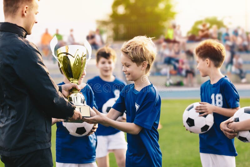 Joyeux jeunes garçons souriants célébrant le championnat de football sportif