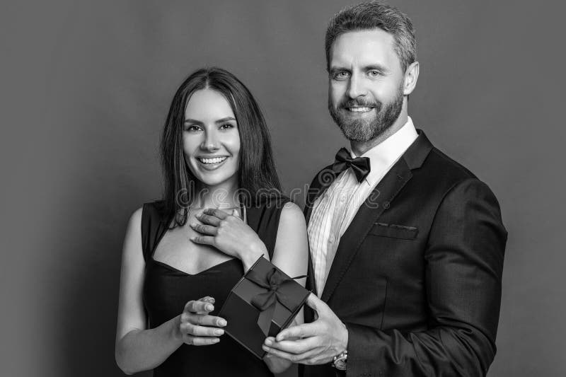 Joyeux jour de Valentines. Couple amoureux isolé sur rouge. Proposition romantique avec cadeau. Présente. Un homme fait une propos photos libres de droits