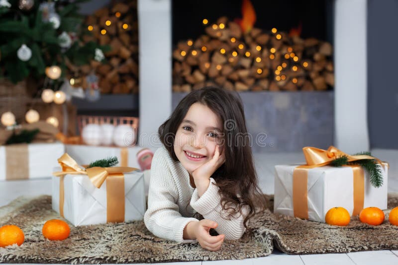 Joyeux Noël, heureux jours fériés ! Nouvel An 2020 Petite fille avec des cadeaux au foyer Joyeux enfant le soir de Noël dans le s image stock Joyeux Noël, heureux jours fériés ! Nouvel An 2020 Petite fille avec des cadeaux au foyer Joyeux enfant le soir de Noël dans le s image stock