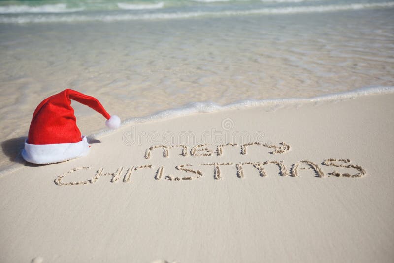 Merry Christmas written on tropical beach white sand with xmas hat. See my other works in portfolio. Merry Christmas written on tropical beach white sand with xmas hat. See my other works in portfolio.