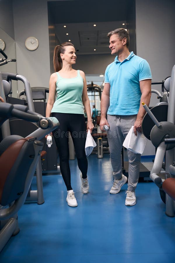 Joyeux partenaires de remise en forme communiquant avant la gym photographie stock