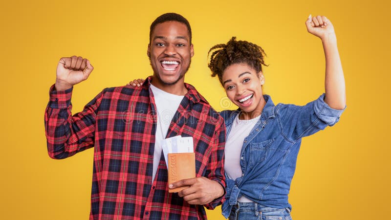 Joyful African Couple Holding Flight Tickets på gul bakgrund arkivbilder