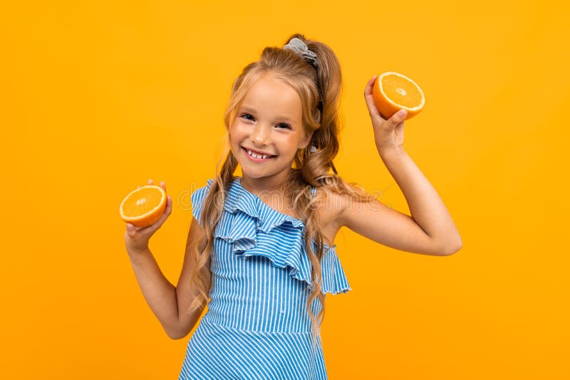 Joyful attractive girl with oranges on a yellow background