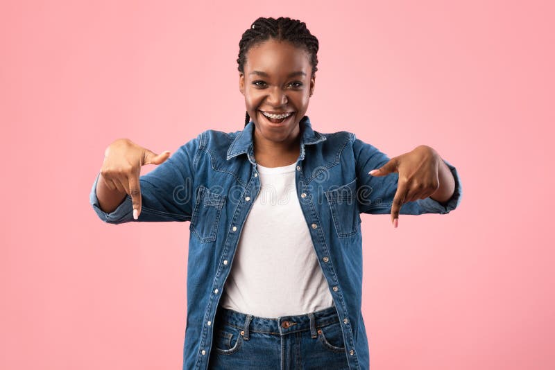 Joyful Black Girl Pointing Fingers Down Posing On Pink Background
